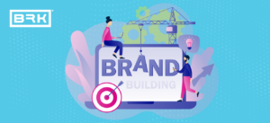 Graphic of people, crane, and target working together on laptop screen displaying the words "BRAND BUILDING.