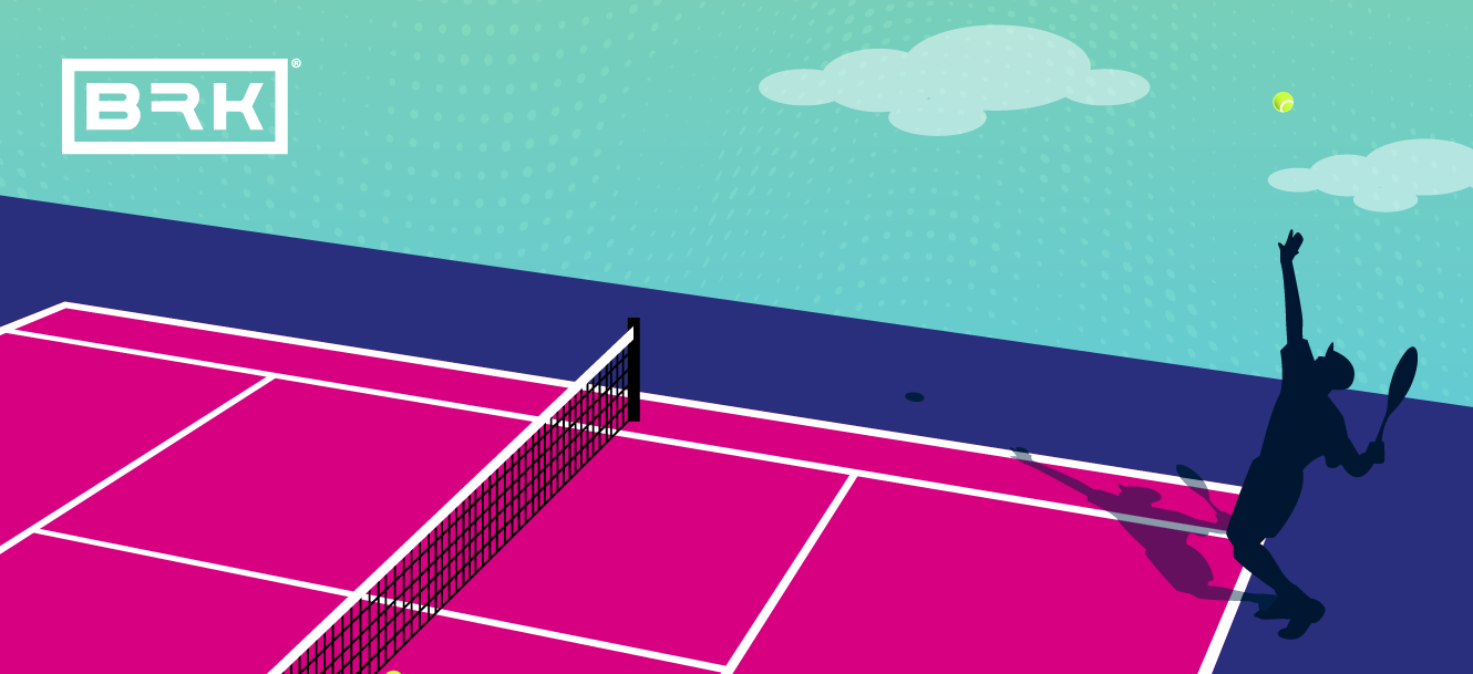 Silhouette of a tennis player serving on a vibrant pink and blue court under a cloudy sky.
