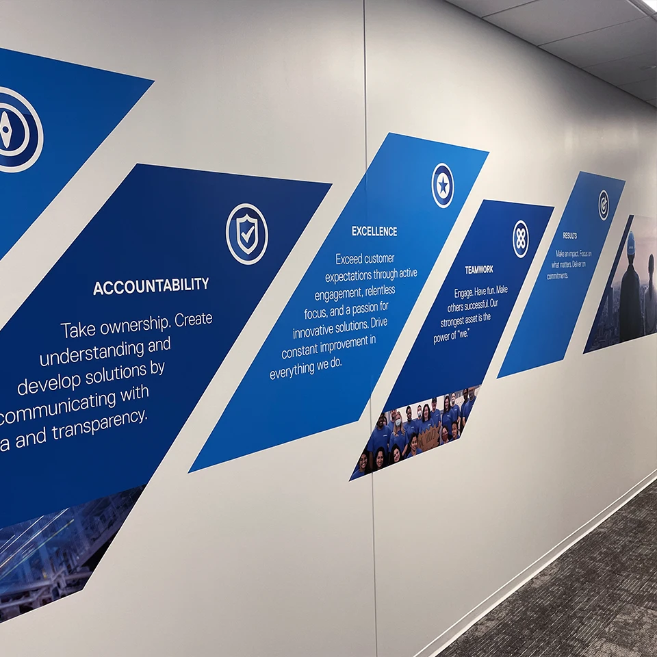 Blue wall with diamond shapes displaying company values: Accountability, Excellence, Teamwork, and Results.
